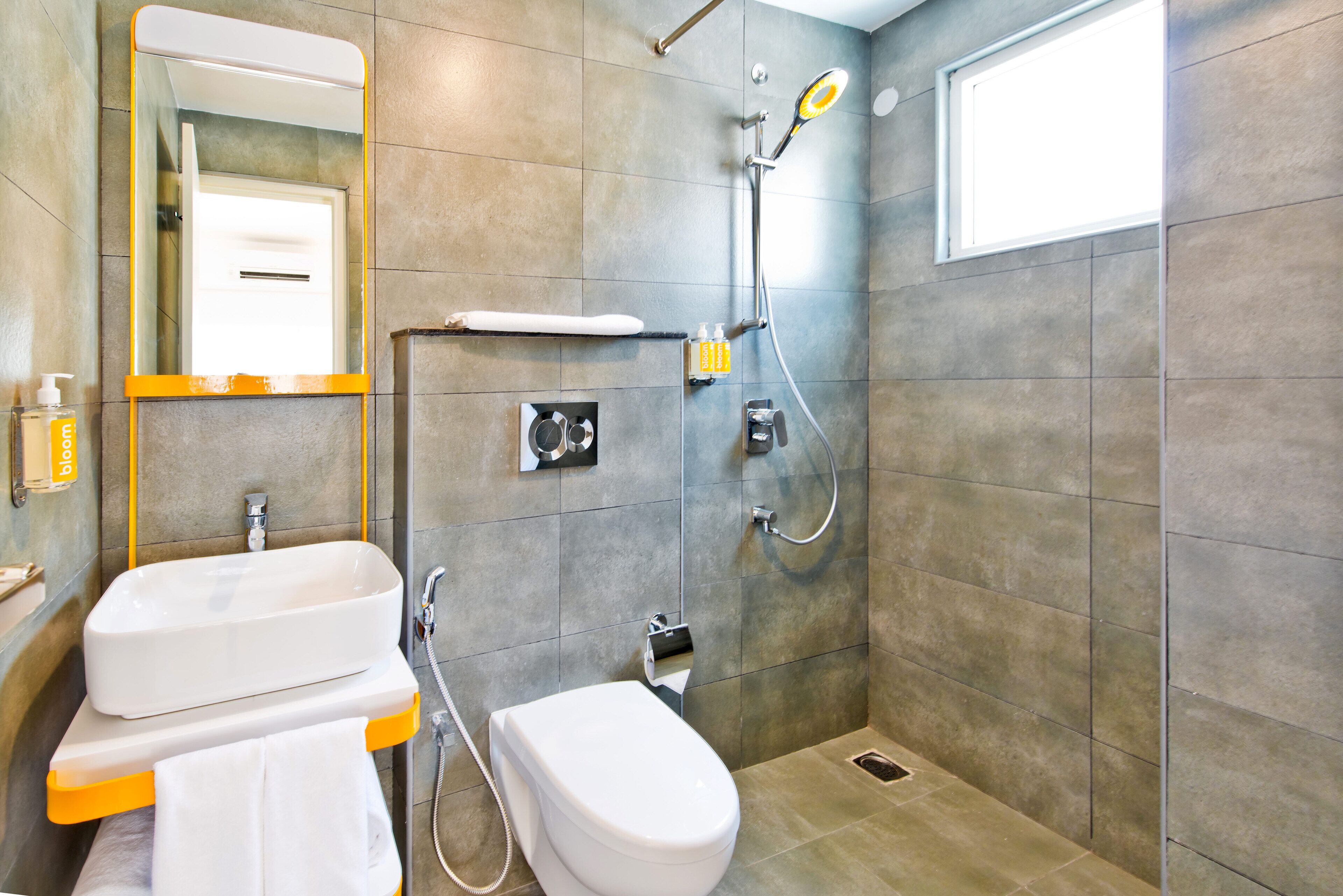 Un baño moderno con lavamanos, inodoro y ducha blancos.
