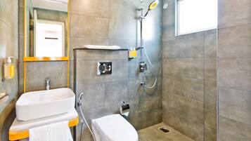 Un baño moderno con lavamanos, inodoro y ducha blancos.