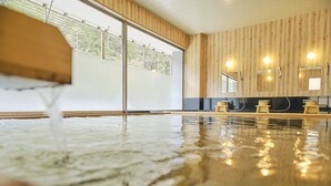 Una piscina interior con paredes de madera y un ventanal de cristal.