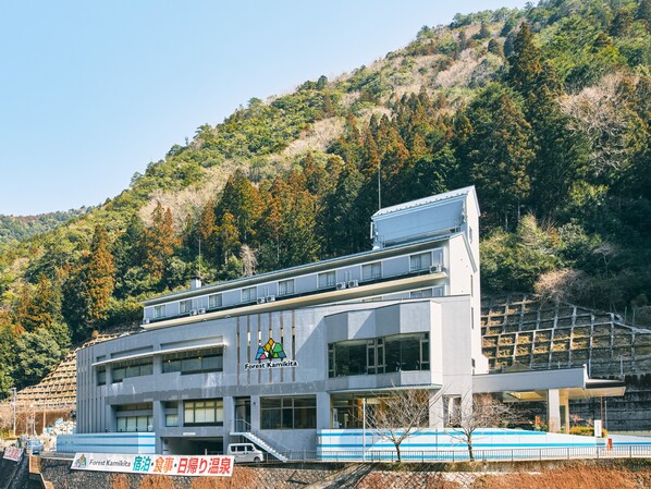 Un edificio moderno con techo plano, ventanas amplias y un letrero que dice "Forest Kamikita".