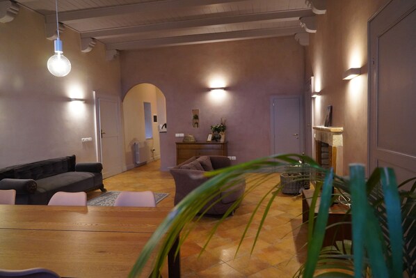 Un amplio espacio habitable con una mesa de comedor de madera, sofás y una chimenea.