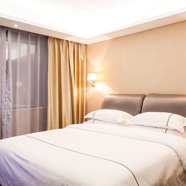 A hotel room with a bed, a lamp, and a window with curtains. - Jundiwan Hotel Xiamen University (Xiamen)