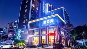 A hotel with a modern facade, illuminated signage, and a visible entrance.