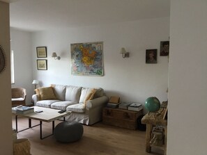 A living room with a sofa, a coffee table, a map on the wall, and a globe on a side table.
