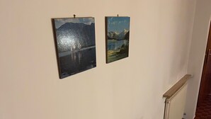Um quarto com uma mesa e duas pinturas na parede.