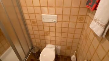 Ein kleines Badezimmer mit Toilette, Bidet und Handtuchhalter.