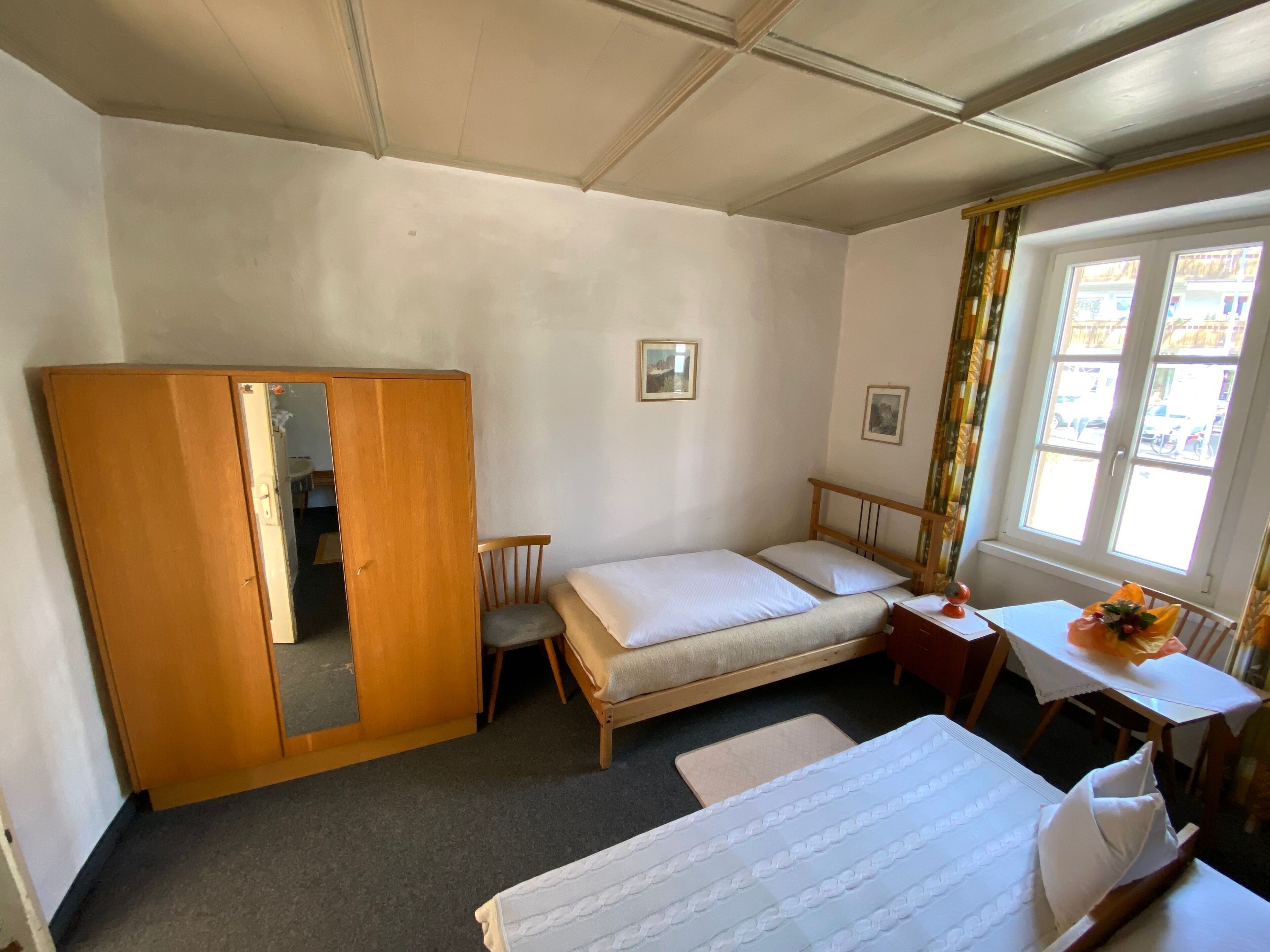 A bedroom with a bed, a desk, a chair, and a wardrobe.