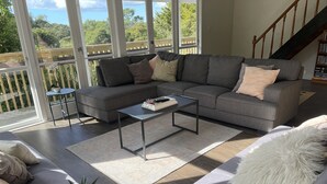 A modern living room with a grey sectional sofa, a small coffee table, and a potted plant.