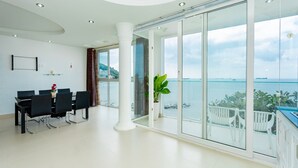 A modern living room with a dining area, large glass windows, and a view of the sea. - Villa Seaview 11 (Ho Chi Minh City)