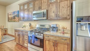 A kitchen with wooden cabinets, stainless steel appliances, and a granite countertop. - Steps to River, Yamaguchi Park, Air Conditioning and Downtown Fun! (Pagosa Springs)