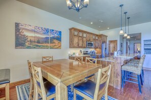 Una cocina amplia con armarios de madera, una isla grande y un comedor con mesa y sillas de madera.