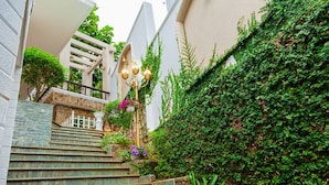 A set of stone steps leading up to a white building with a balcony. - Villa Seaview 1 (Ho Chi Minh City)