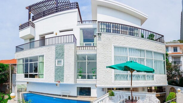 A modern two-story house with a swimming pool, outdoor seating, and a balcony. - Villa Seaview 1 (Ho Chi Minh City)