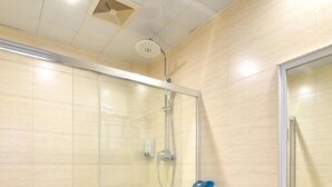 Une salle de bain moderne avec une douche à l’italienne en verre, des toilettes blanches et un plan de toilette noir avec un lavabo.