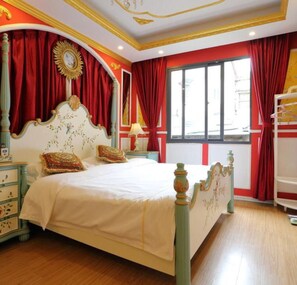 Quarto com cama grande, cortinas vermelhas e janela.