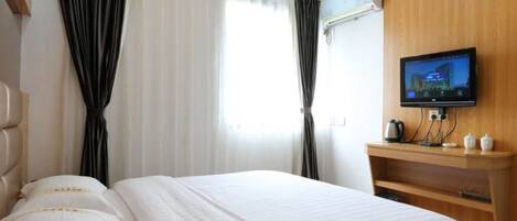 Ein Hotelzimmer mit Bett, Fernseher und einer Wand aus Holzverkleidung.