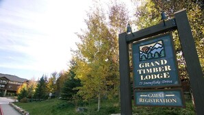 Señal para Grand Timber Lodge con indicaciones para el registro de huéspedes.