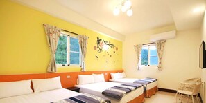A hotel room with three beds, two windows with curtains, a small table, and a chair.