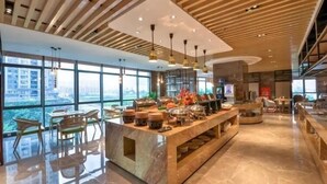 A modern hotel lobby with a marble reception desk, wooden ceiling, and large windows offering city views. - Sibeisi International Hotel (Quanzhou)