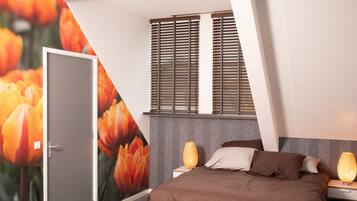 Un dormitorio moderno con cama, mesitas de noche, lámpara de pared y una puerta.