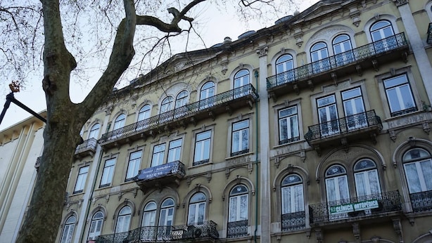 Un edificio a più piani con balconi decorati e ampie finestre.