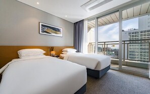 A hotel room with two beds, a large window, and a city view. - Lavi de Atlan Hotel (Busan)