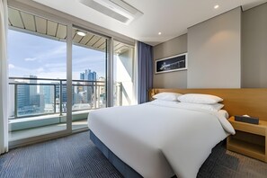 A hotel room with a large bed, a TV, a city view, and a balcony. - Lavi de Atlan Hotel (Busan)