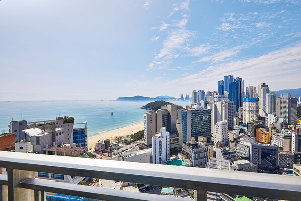 A cityscape with high-rise buildings, a beach, and a clear sky. - Lavi de Atlan Hotel (Busan)
