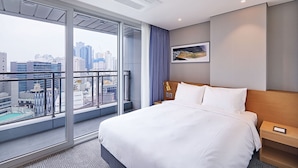 A hotel room with a large window, a bed, a nightstand, and a painting on the wall. - Lavi de Atlan Hotel (Busan)