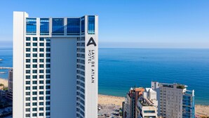 A high-rise hotel with a prominent 'A' sign, overlooking a beach and the sea. - Lavi de Atlan Hotel (Busan)