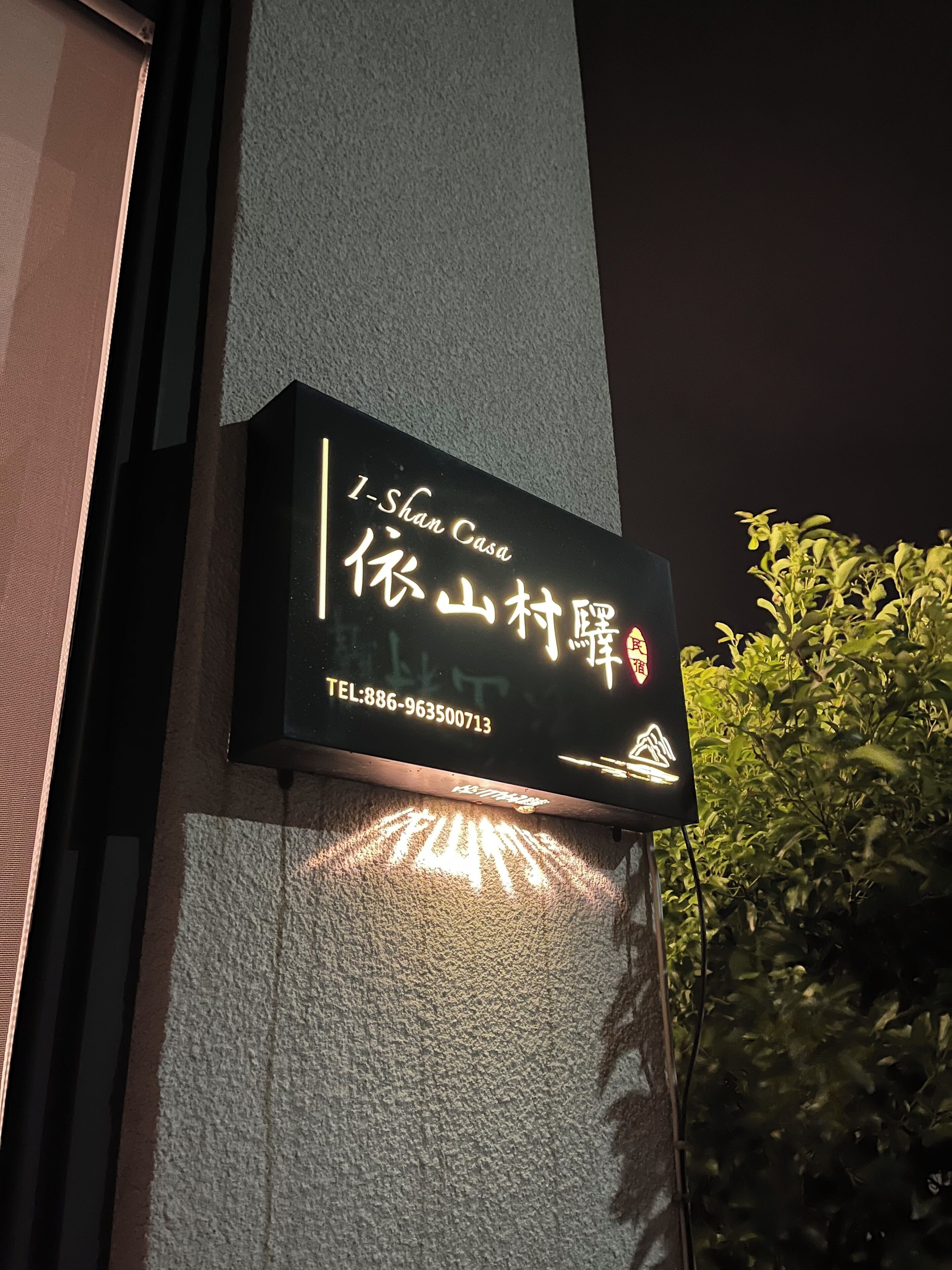 A signboard for I-Shan Casa with Chinese characters and a contact number.