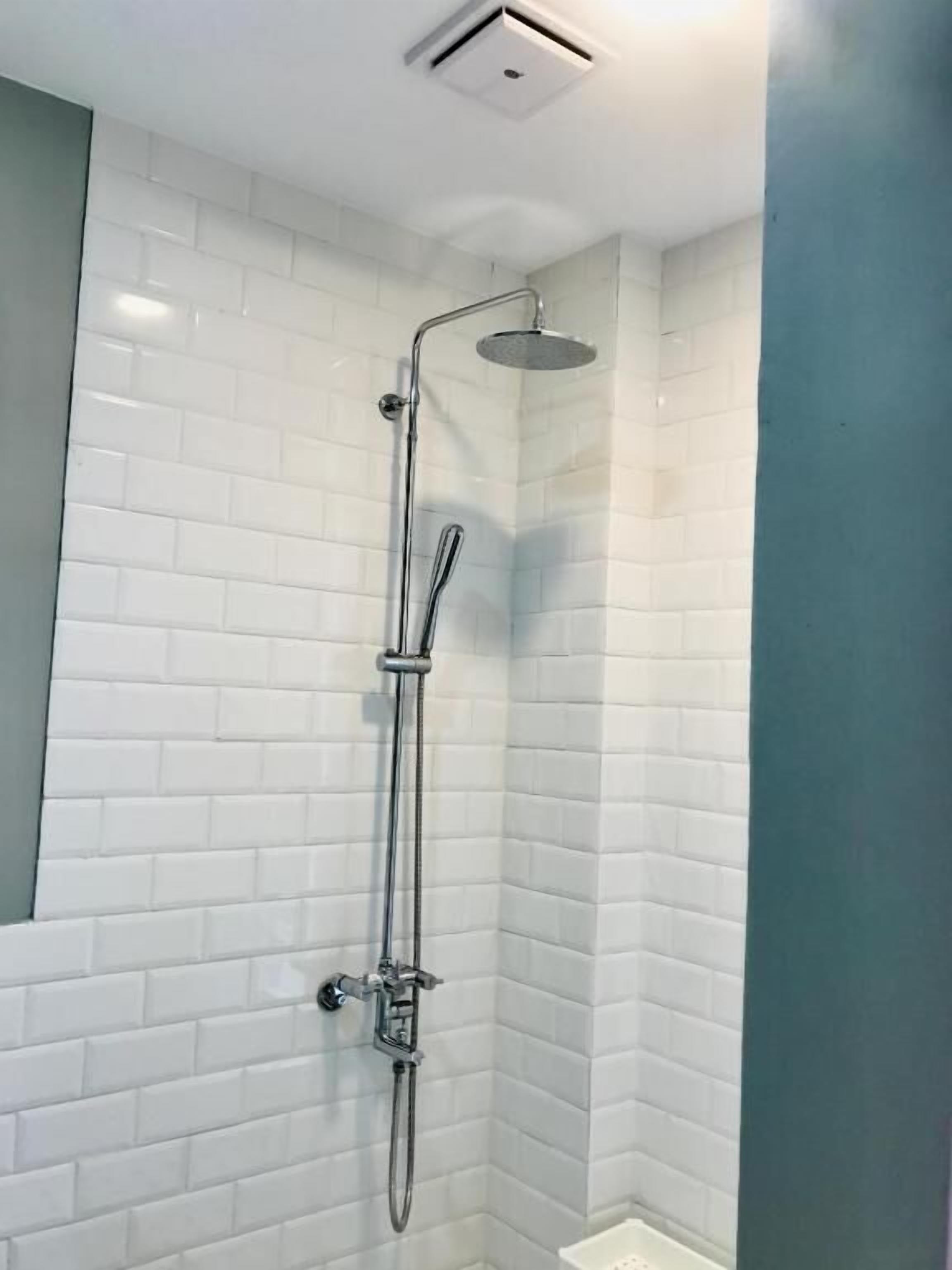 Eine Dusche mit Handbrause und Deckenbrause.