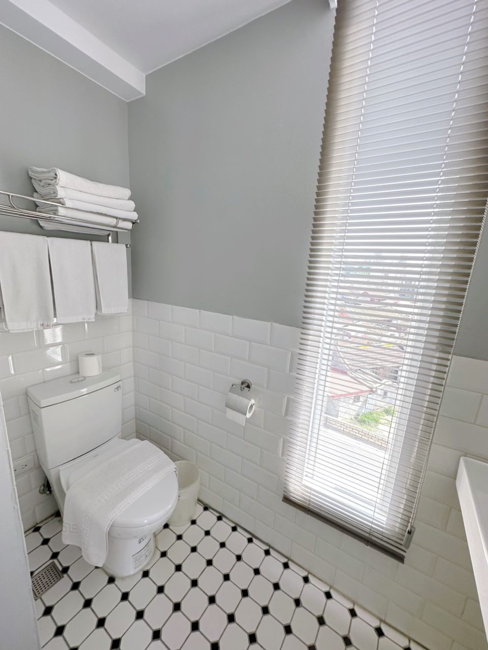 A bathroom with a toilet, a towel rack, and a toilet paper holder.