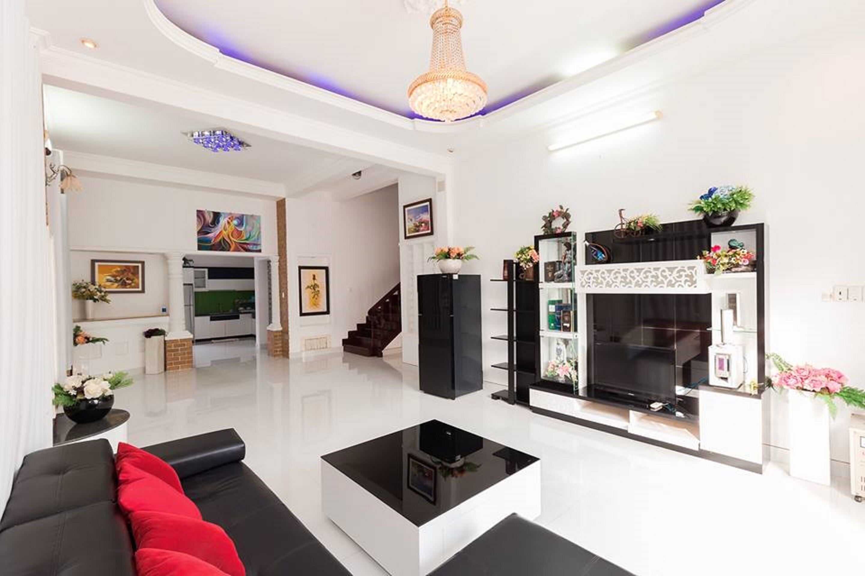 A modern living room with a black sofa, a glass coffee table, and a fireplace.