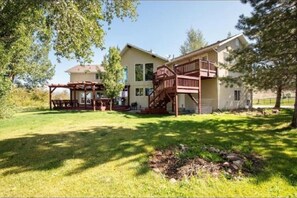 A two-story house with a covered patio and a wooden staircase leading to a deck. - Entire River Ranch House, Mtn Views, Park City, Ski, Horses, Hot tub, 18 acres (Kamas)