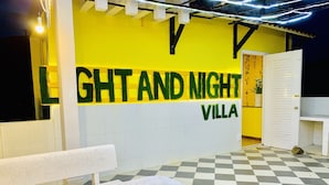 Een geruite vloer en een bankje voor een muur met de tekst 'GHT AND NIGHT VILLA'.