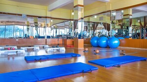 Een sportschool met fitnessmatten, gewichten en grote trainingsballen.