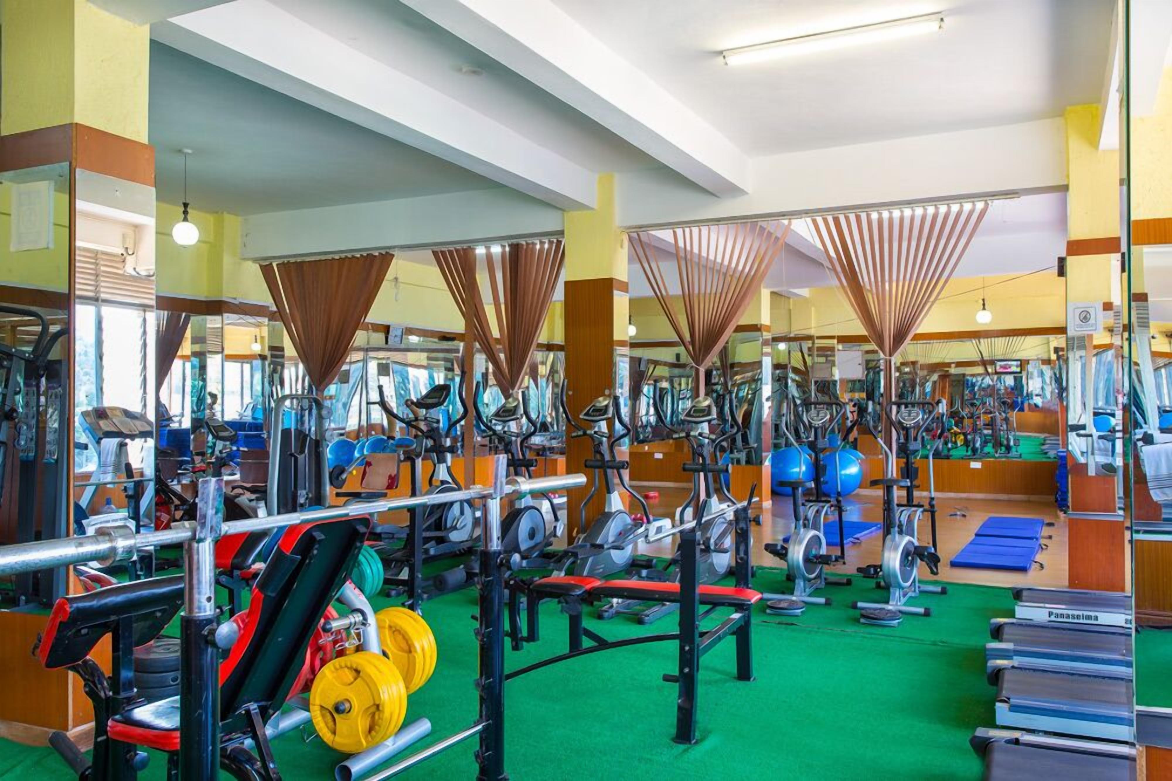 A gym with various exercise equipment, including treadmills, stationary bikes, and weight machines.