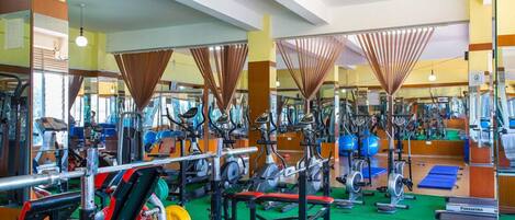 A gym with various exercise equipment, including treadmills, stationary bikes, and weight machines.
