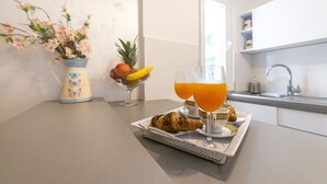 A breakfast tray with croissant, fruit, and orange juice on a kitchen counter. - Villa Boro 2 (Dubrovnik)