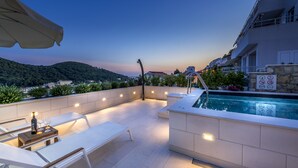 An outdoor terrace with lounge chairs, a pool, and a view of the surrounding landscape. - Villa Boro 2 (Dubrovnik)