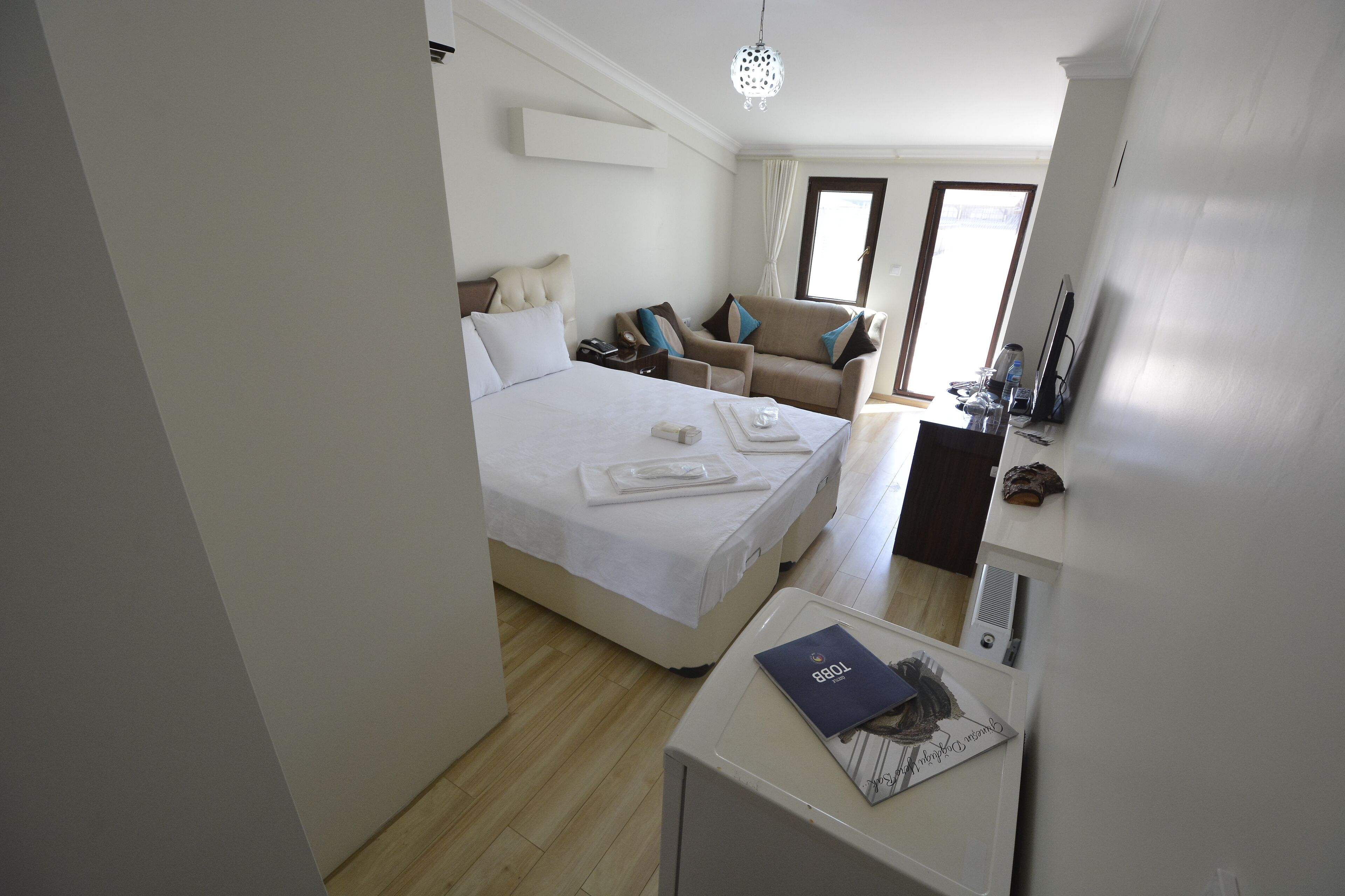 A hotel room with a bed, a desk, a chair, and a sofa.
