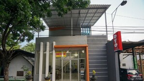 A building with a storefront, a sign reading "CHOC 88", and a parked car. - Hotel O Choco 88 Residence (Dringu)
