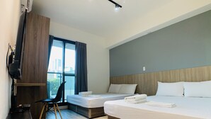 A hotel room with a large bed, a smaller bed, a desk with a chair, a television, and a window with curtains. - Taichung Wululu (Taichung)