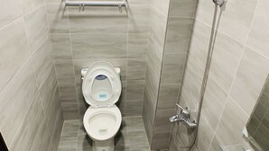 A small, modern bathroom with a toilet, a shower, and a window above the toilet. - Taichung Wululu (Taichung)
