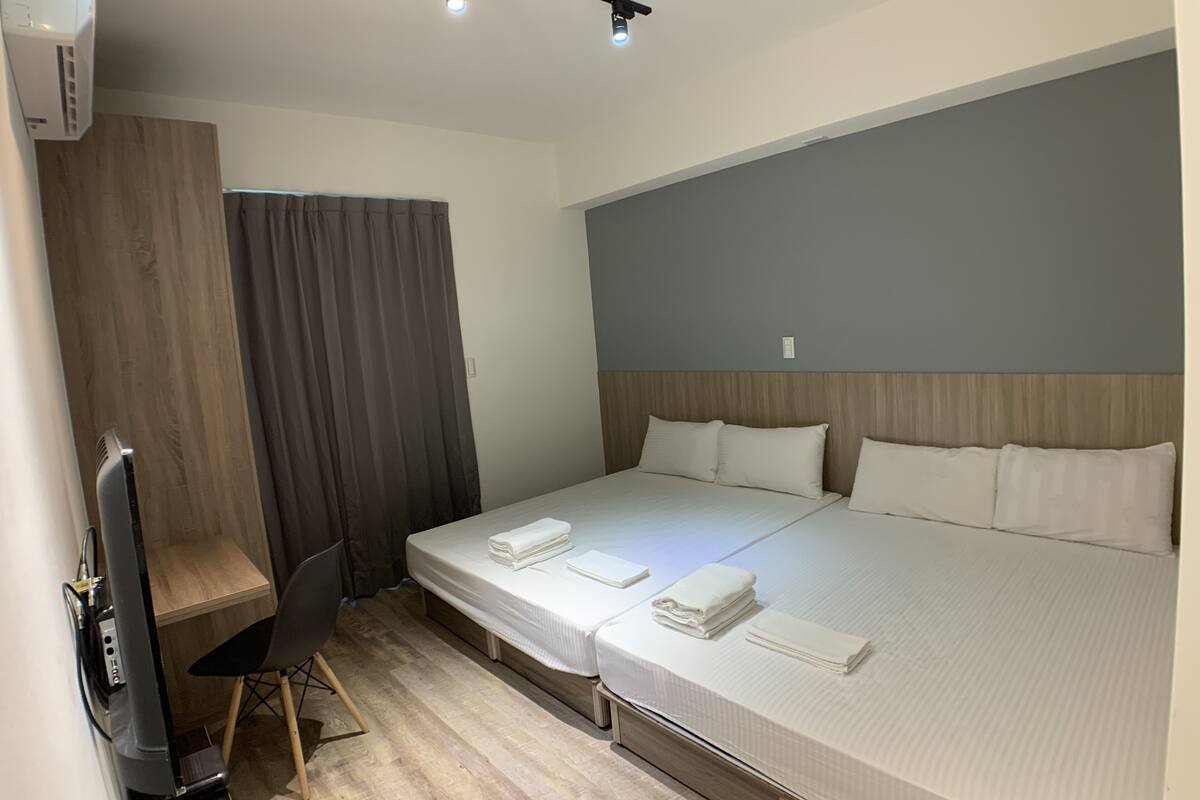 A hotel room with a bed, a desk, and a chair.