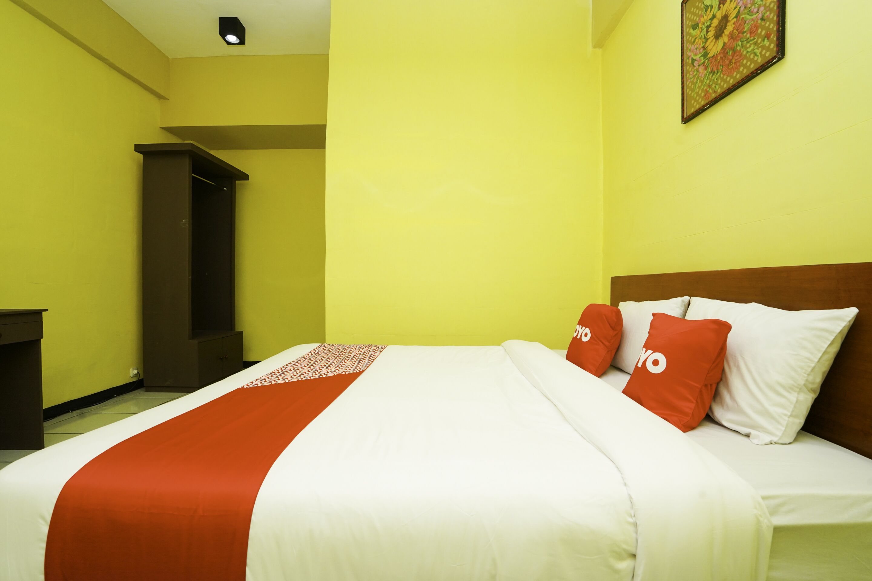 A hotel room with a bed, a desk, and a wardrobe.