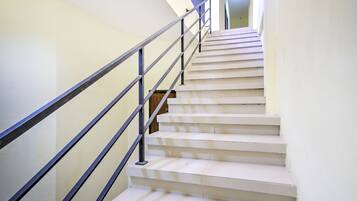 A staircase with a metal railing, leading to a landing.