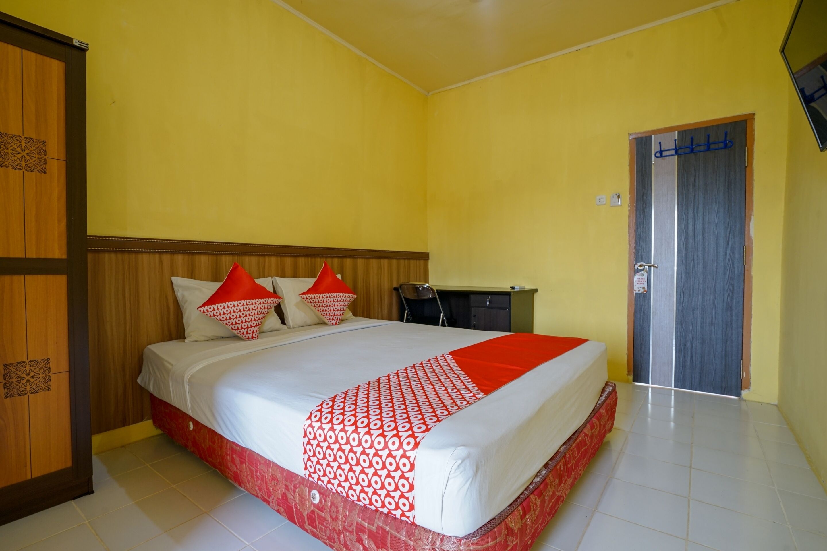 A hotel room with a bed, a desk, and a wardrobe.