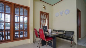 Una habitación con un ventanal grande, una mesa con sillas, un sofá y un letrero en la pared que dice "OYO".
